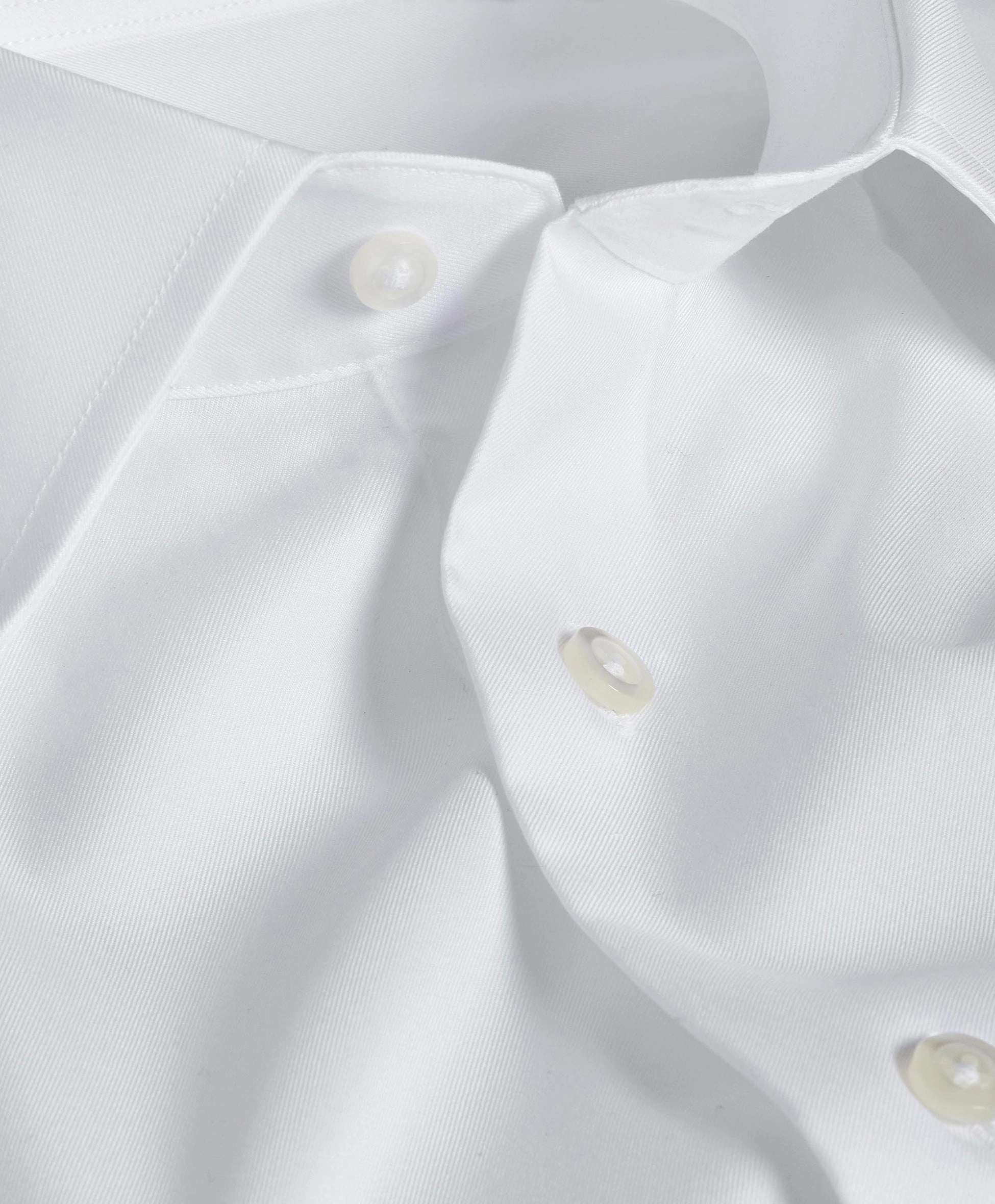 Close view of a white shirt collar and buttons