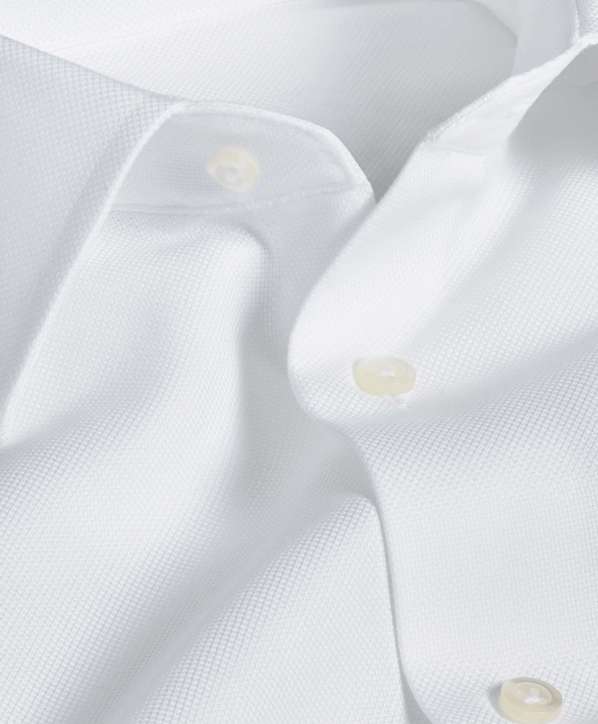 Close view of a white shirt placket with a cream button