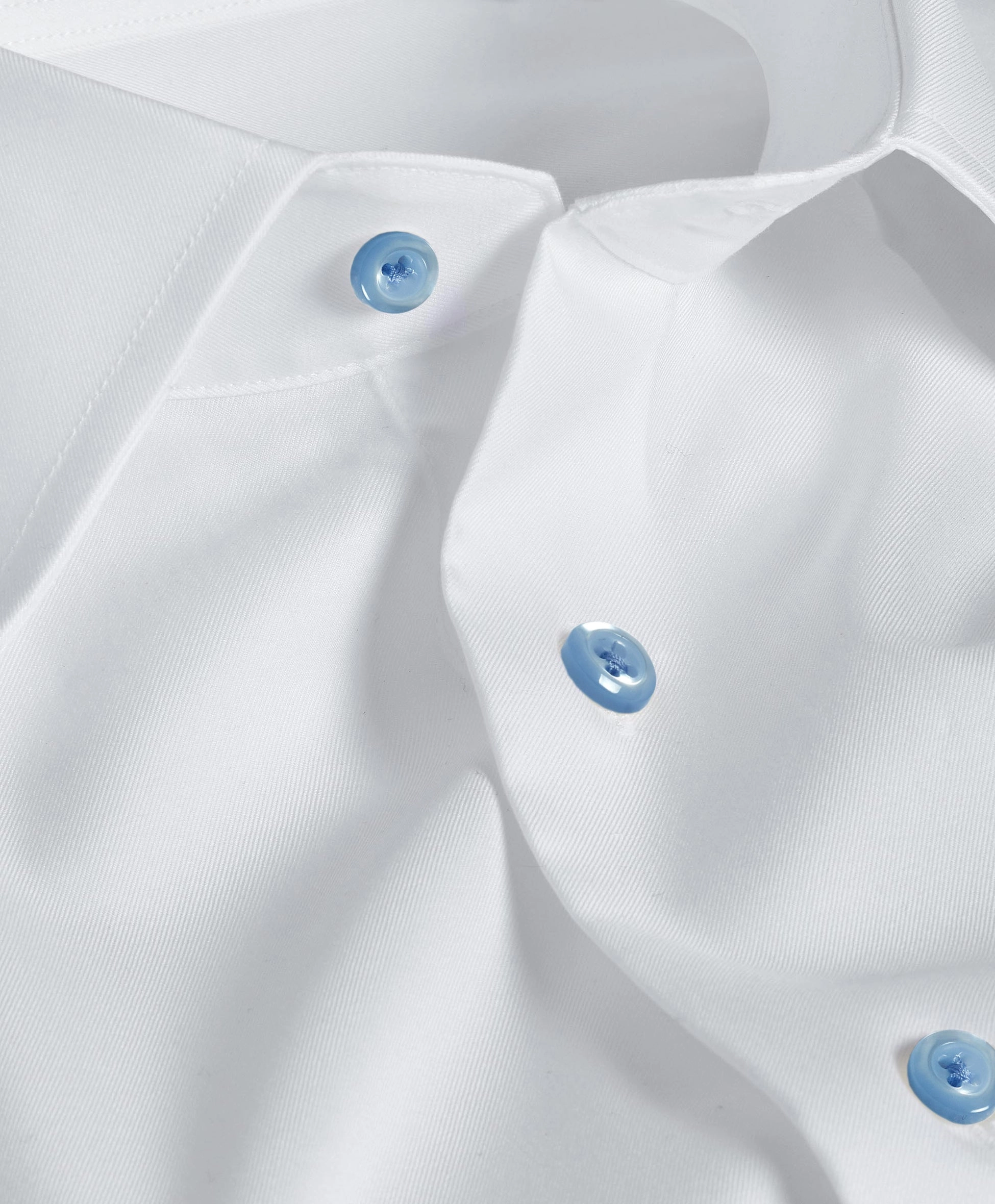 Close view of a white shirt with pale blue buttons