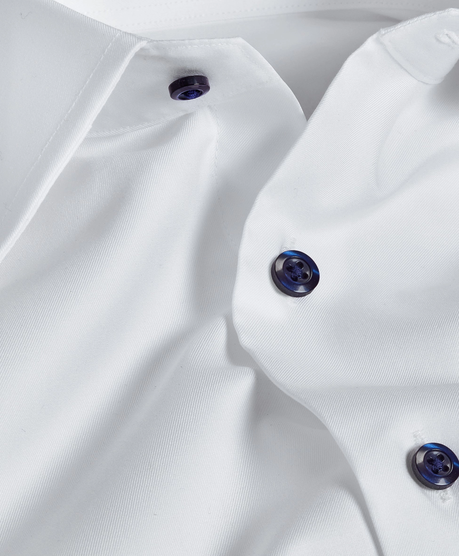 Close view of a white shirt with navy buttons